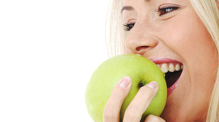 Frau beißt in einen Apfel